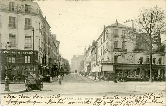 La rue prise depuis l’avenue de Saint Cloud, avec l’Hôtel de Ville au fond. Déballage devant le magasin Dufayel, à droite.