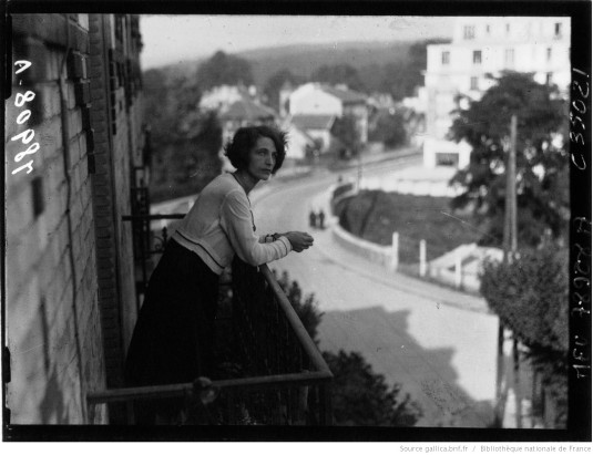 Mme Bellonte sur son balcon rue Carnot. En arrière plan le pont de l’avenue Gaston Boissier.. Photo de presse Meurice, Paris, septembre 1930, négatif sur verre 13x18. Fonds Gallica, Bibliothèque Nationale de France. Recherche ’Bellonte’