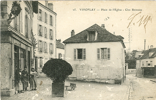 Autre vue du café de la place, avec des arbustes, et du clos Boisseau. Au fond, la rue de Versailles montre la boulangerie et le Grand Chalet. (CPA)
