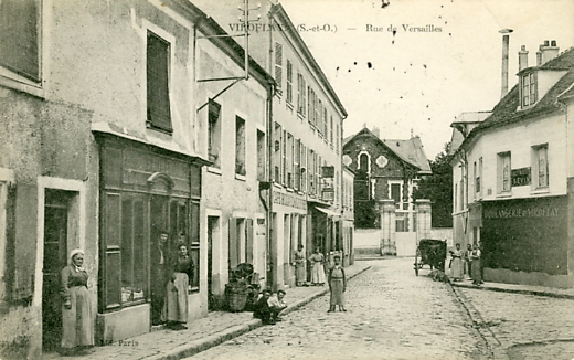 Le coeur du Village, rue de Versailles, avec l’Hôtel de Morny au fond. Plusieurs commerces, café billard de l’elysée, la boulangerie CPA (coll. part.)